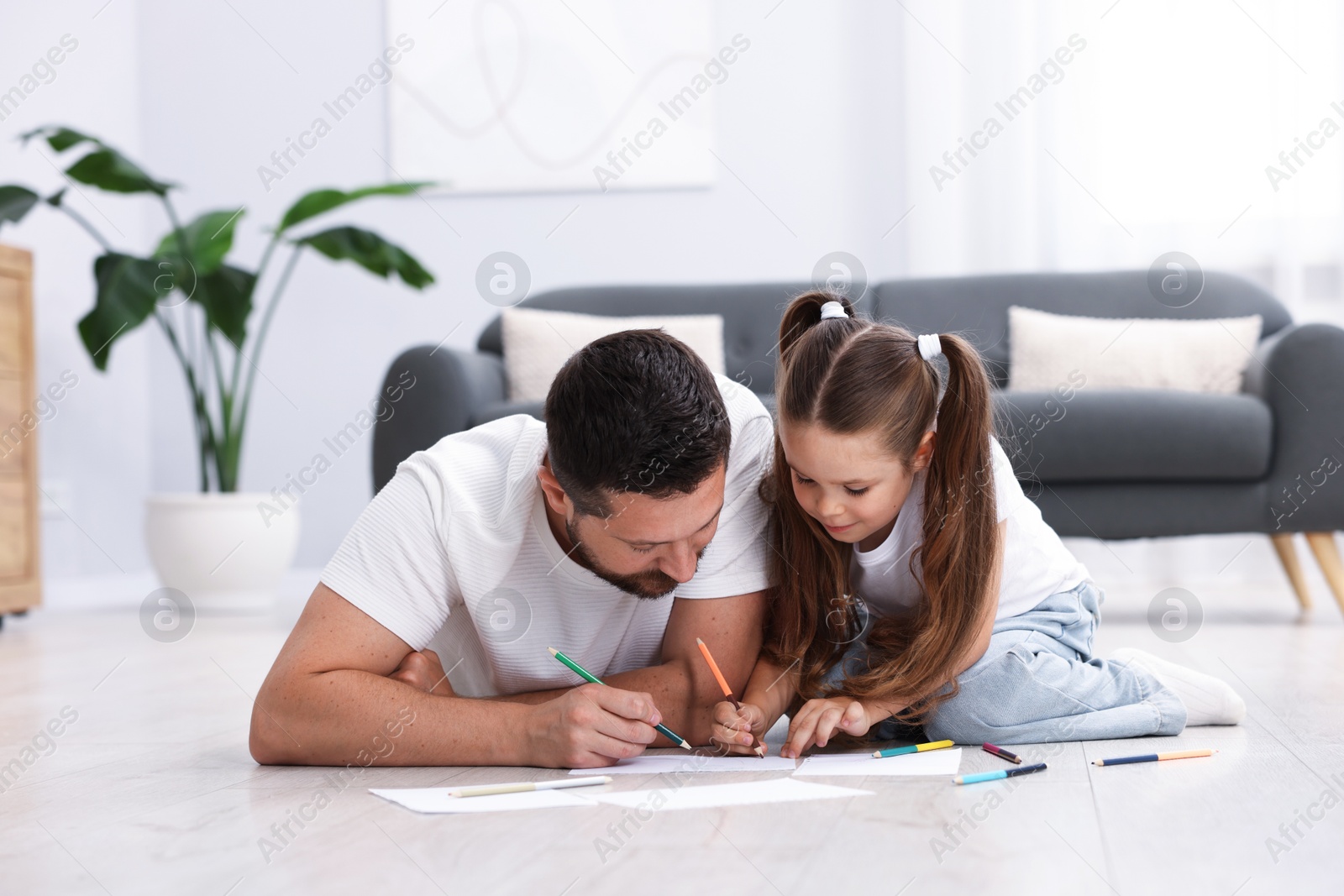 Father and his daughter drawing together on warm floor at home. Heating system Photo of Father and his daughter drawing together on warm floor at home. Heating system