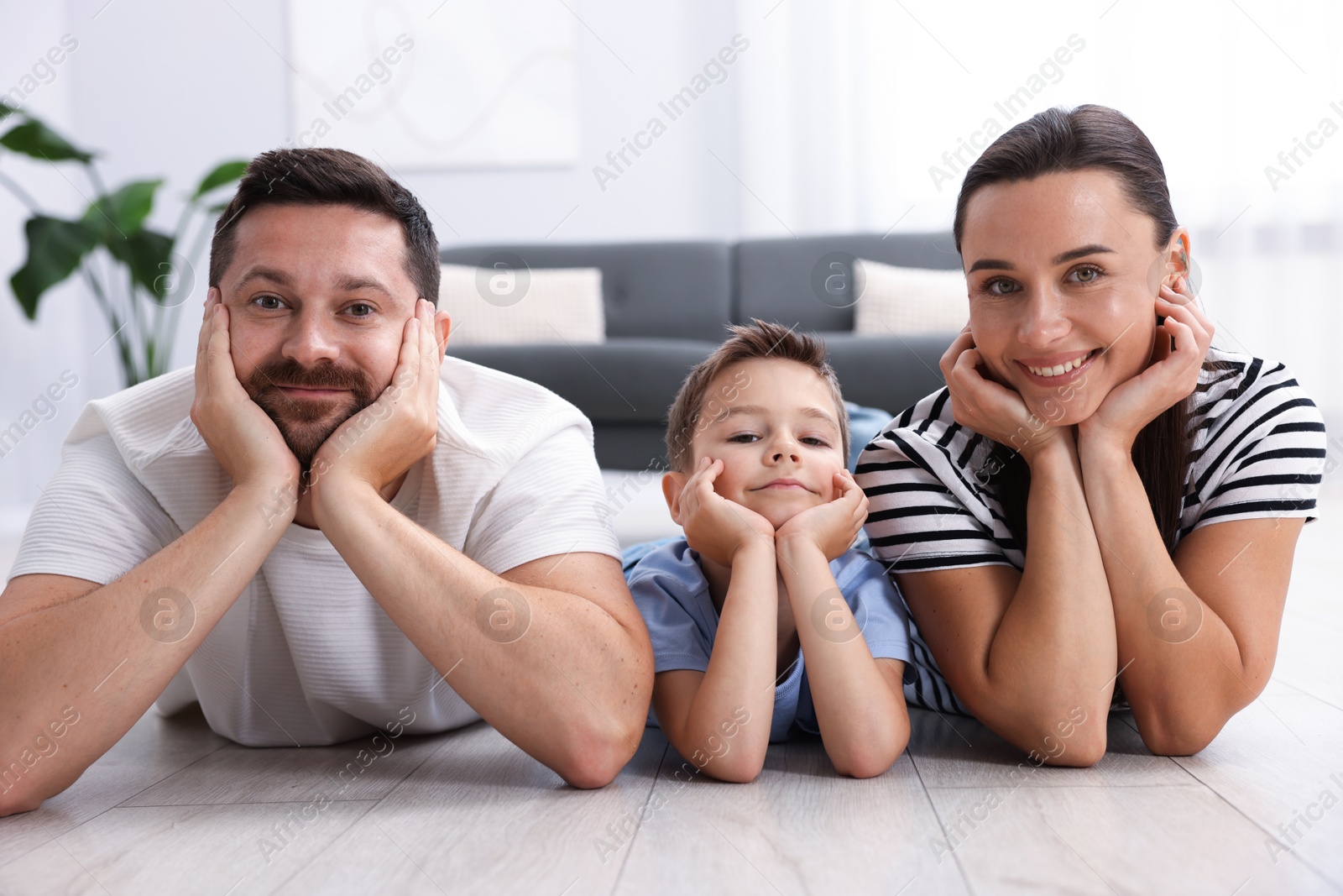 Parents and their son together on warm floor at home. Heating system Photo of Parents and their son together on warm floor at home. Heating system