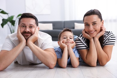 Photo of Parents and their son together on warm floor at home. Heating system