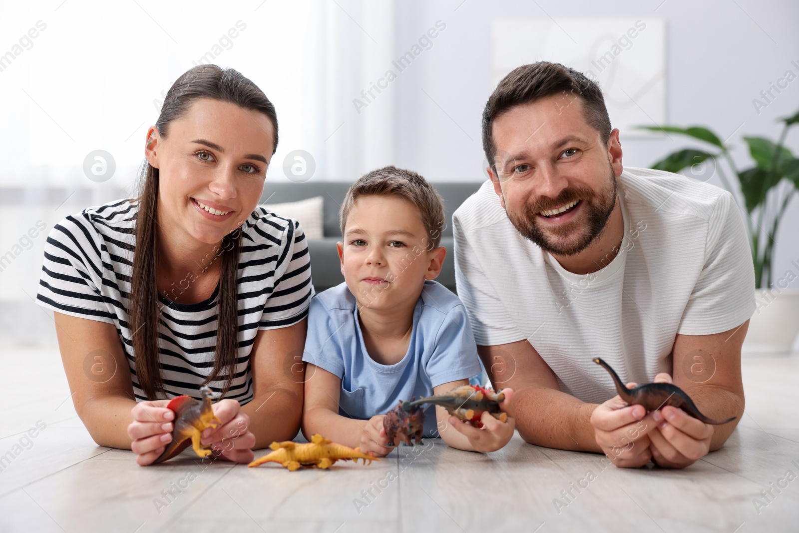 Parents and their son playing with toys on warm floor at home. Heating system Photo of Parents and their son playing with toys on warm floor at home. Heating system