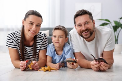 Photo of Parents and their son playing with toys on warm floor at home. Heating system
