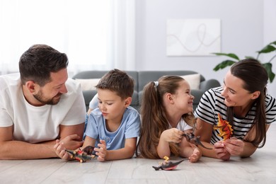 Photo of Parents and their kids playing with toys on warm floor at home. Heating system