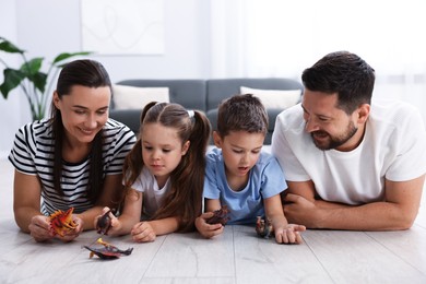 Photo of Parents and their kids playing with toys on warm floor at home. Heating system