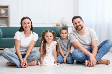 Photo of Parents and their kids together on warm floor at home. Heating system