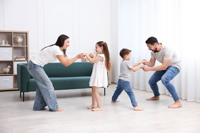 Photo of Parents and their kids spending time together on warm floor at home. Heating system