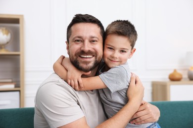 Photo of Happy father and his son hugging at home