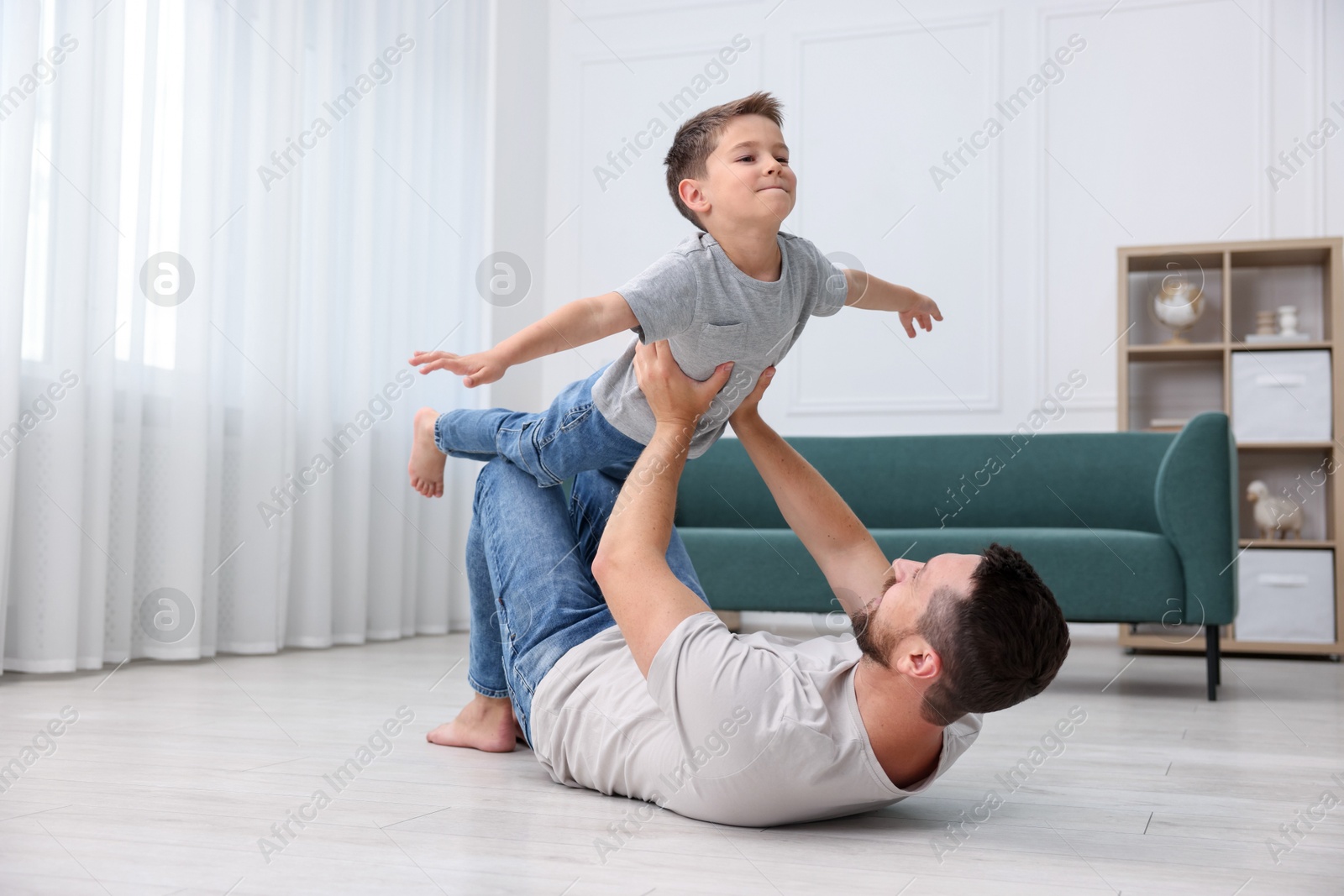 Father and his son spending time together on warm floor at home. Heating system Photo of Father and his son spending time together on warm floor at home. Heating system