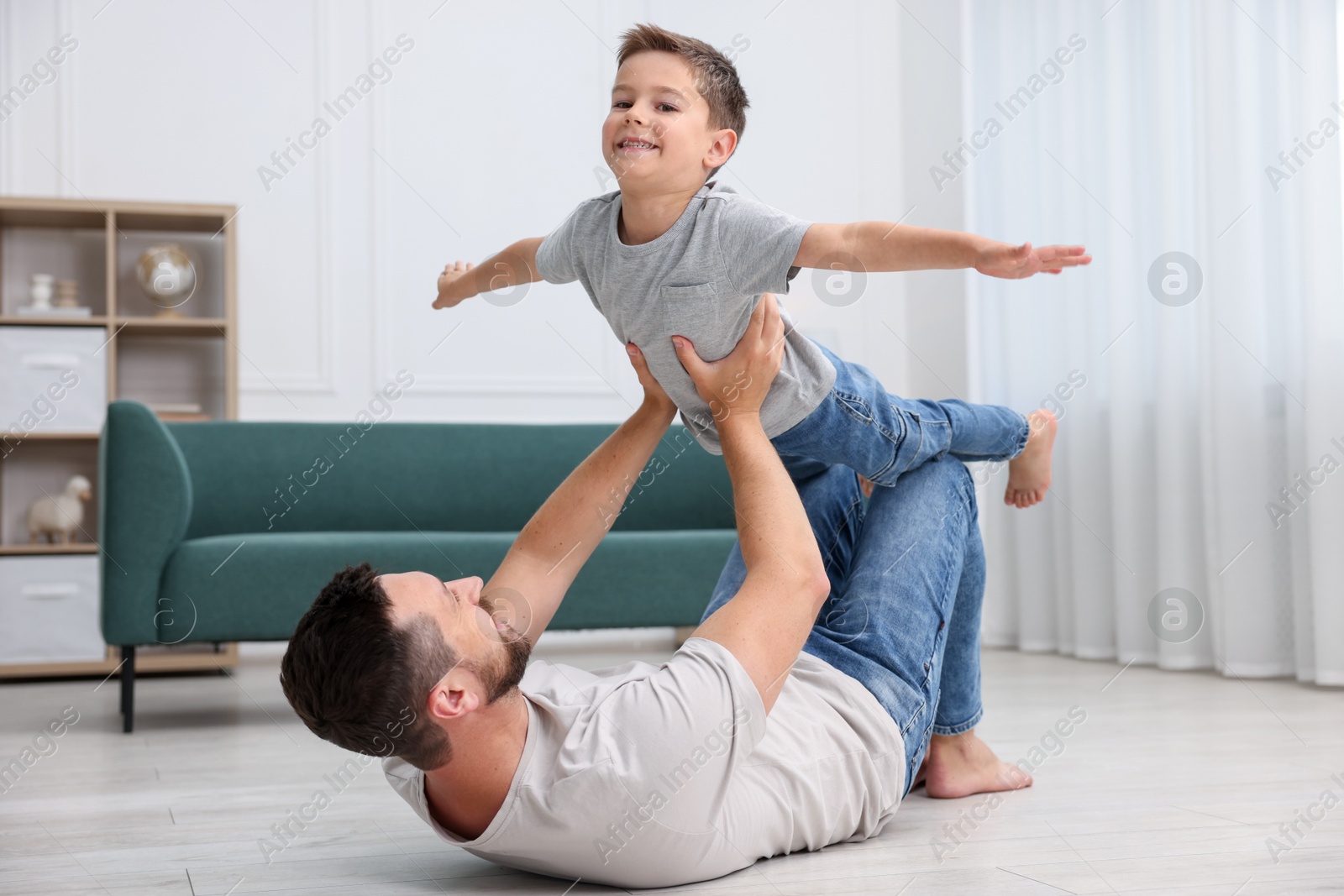 Father and his son spending time together on warm floor at home. Heating system Photo of Father and his son spending time together on warm floor at home. Heating system