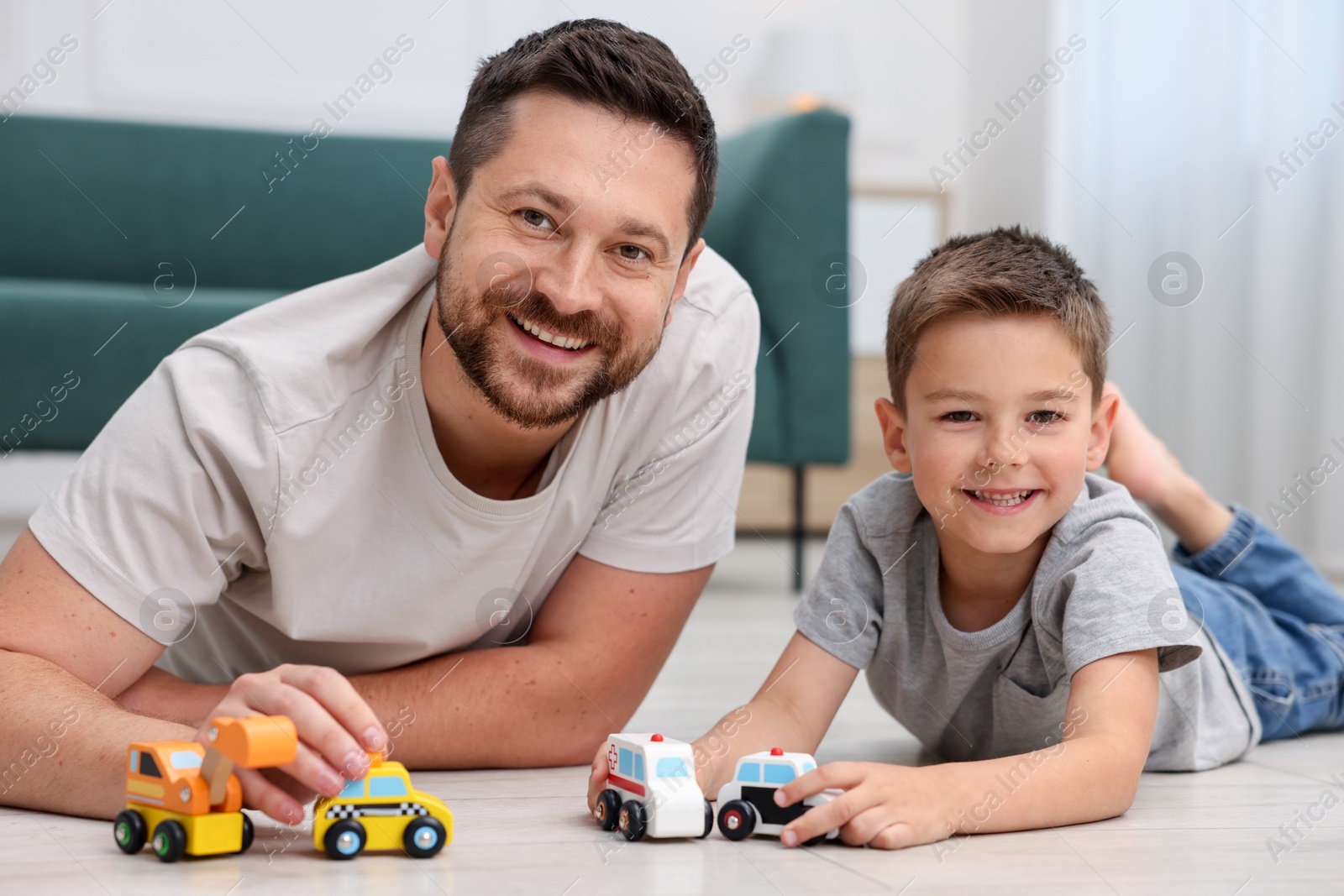 Father and his son playing with toys on warm floor at home. Heating system Photo of Father and his son playing with toys on warm floor at home. Heating system