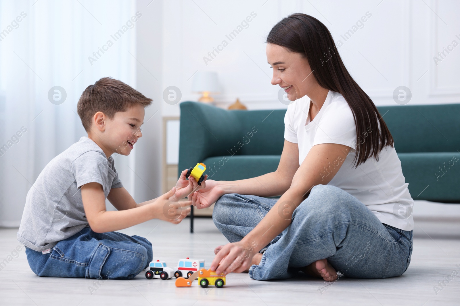 Mother and her son playing with toys on warm floor at home. Heating system Photo of Mother and her son playing with toys on warm floor at home. Heating system