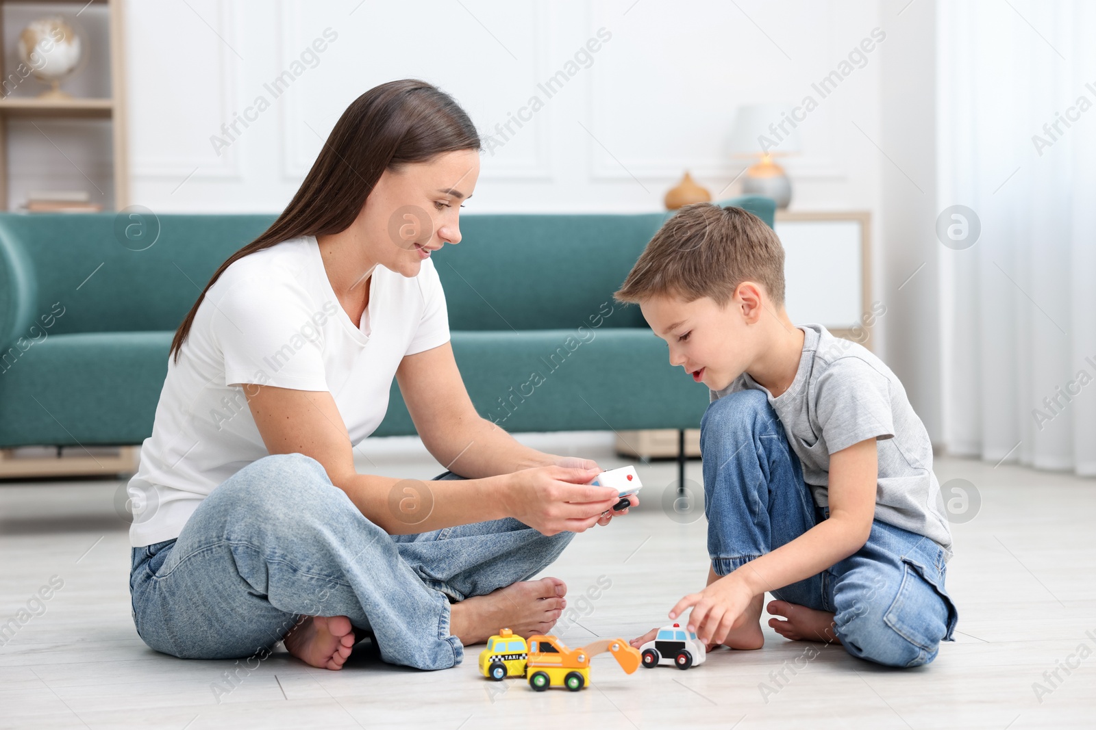 Mother and her son playing with toys on warm floor at home. Heating system Photo of Mother and her son playing with toys on warm floor at home. Heating system