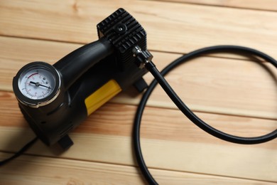Photo of One modern tire inflator on wooden background, closeup