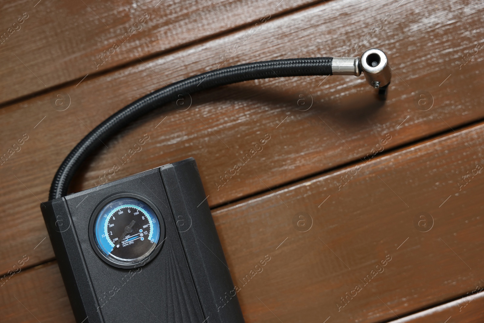 Photo of One tire inflator on wooden background, closeup