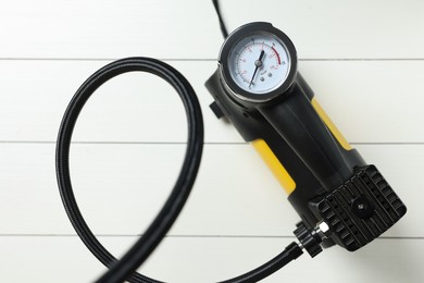 Photo of One modern tire inflator on white wooden background, top view
