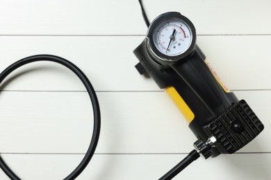 Photo of One modern tire inflator on white wooden background, top view