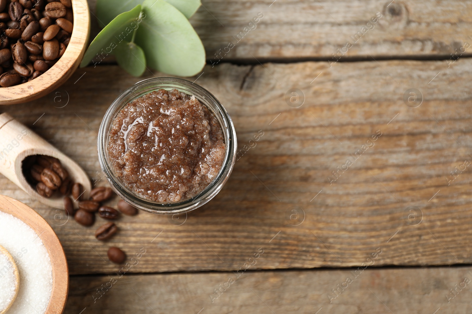 Photo of Natural body scrub and coffee beans on wooden table, flat lay. Space for text