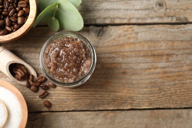 Photo of Natural body scrub and coffee beans on wooden table, flat lay. Space for text