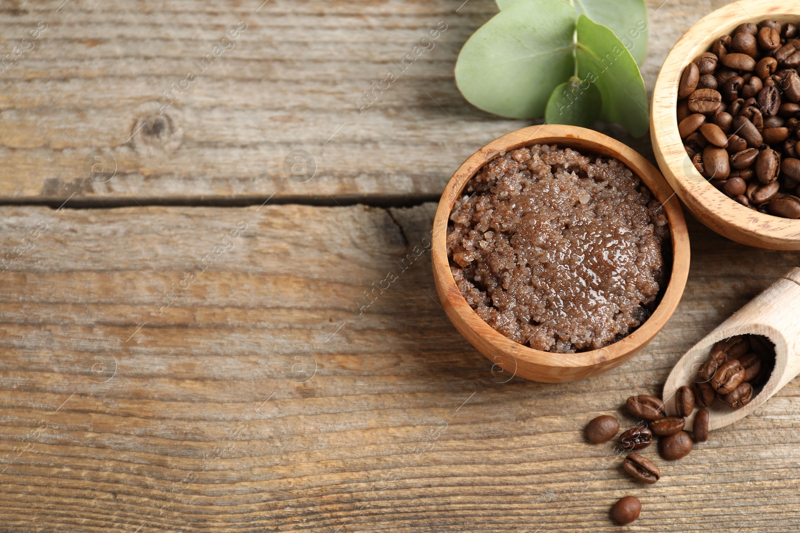 Photo of Natural body scrub and coffee beans on wooden table, flat lay. Space for text