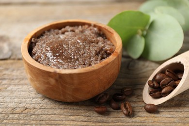 Photo of Natural body scrub and coffee beans on wooden table, closeup