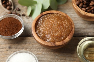 Photo of Natural body scrub and ingredients on wooden table, closeup