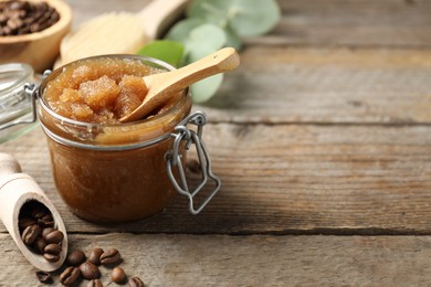 Photo of Natural body scrub and coffee beans on wooden table, closeup. Space for text