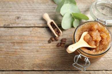 Photo of Natural body scrub and coffee beans on wooden table, above view. Space for text