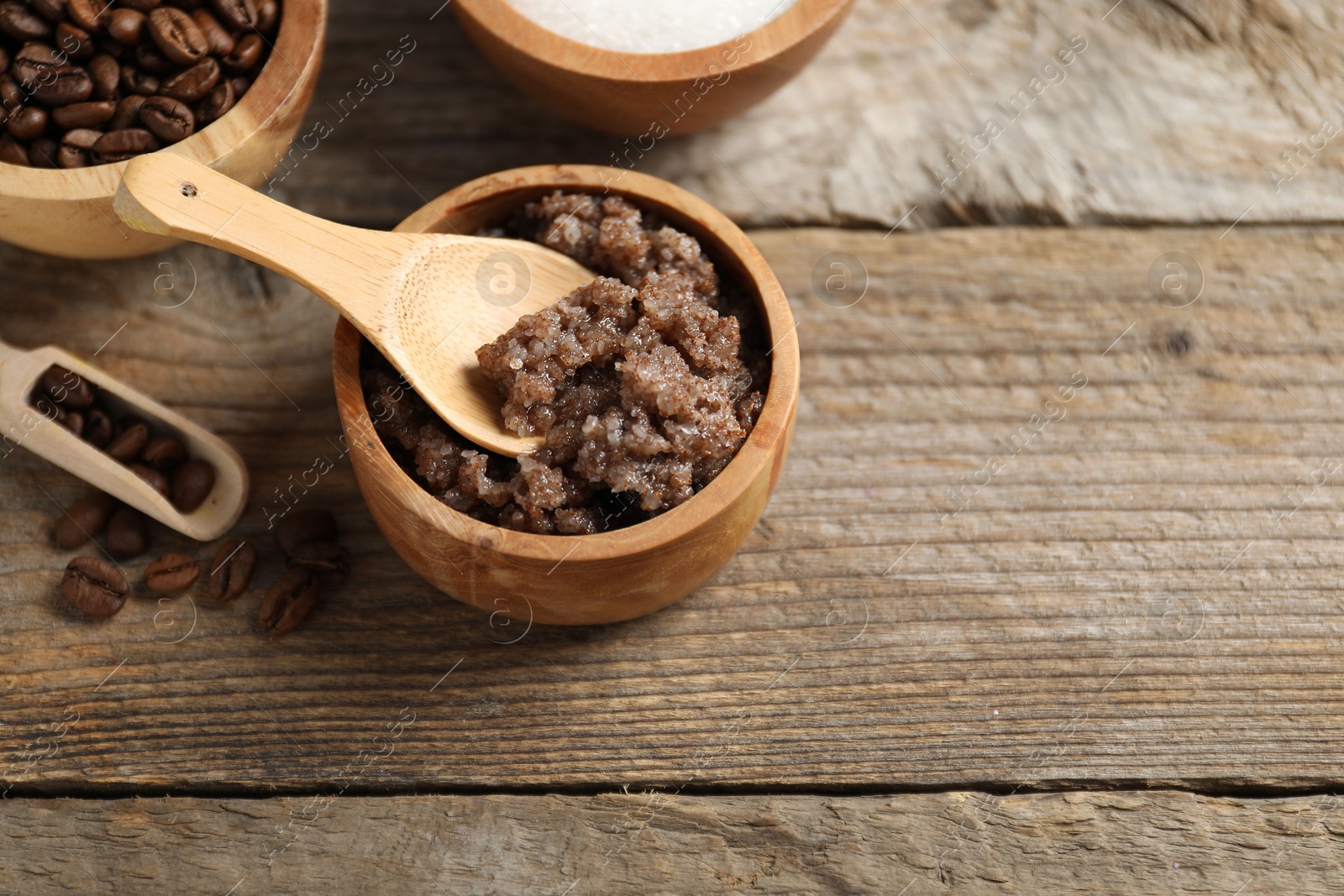 Photo of Natural body scrub and ingredients on wooden table, above view. Space for text