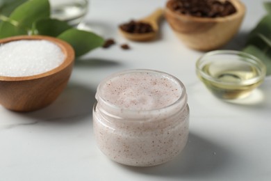 Photo of Natural body scrub and ingredients on white table, closeup