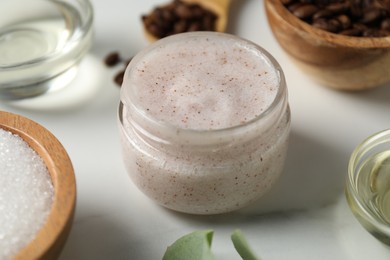 Photo of Natural body scrub and ingredients on white table, closeup