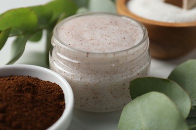 Photo of Natural body scrub and ingredients on white table, closeup