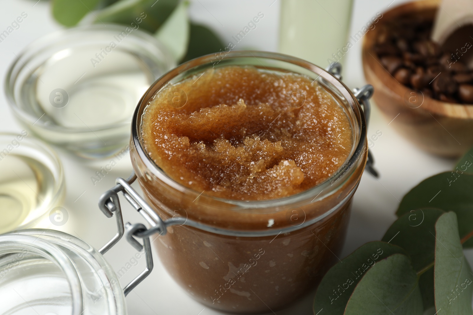 Photo of Natural body scrub and ingredients on white table, closeup