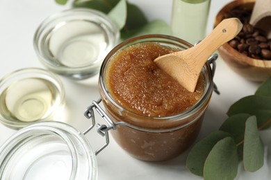 Photo of Natural body scrub and ingredients on white table, closeup