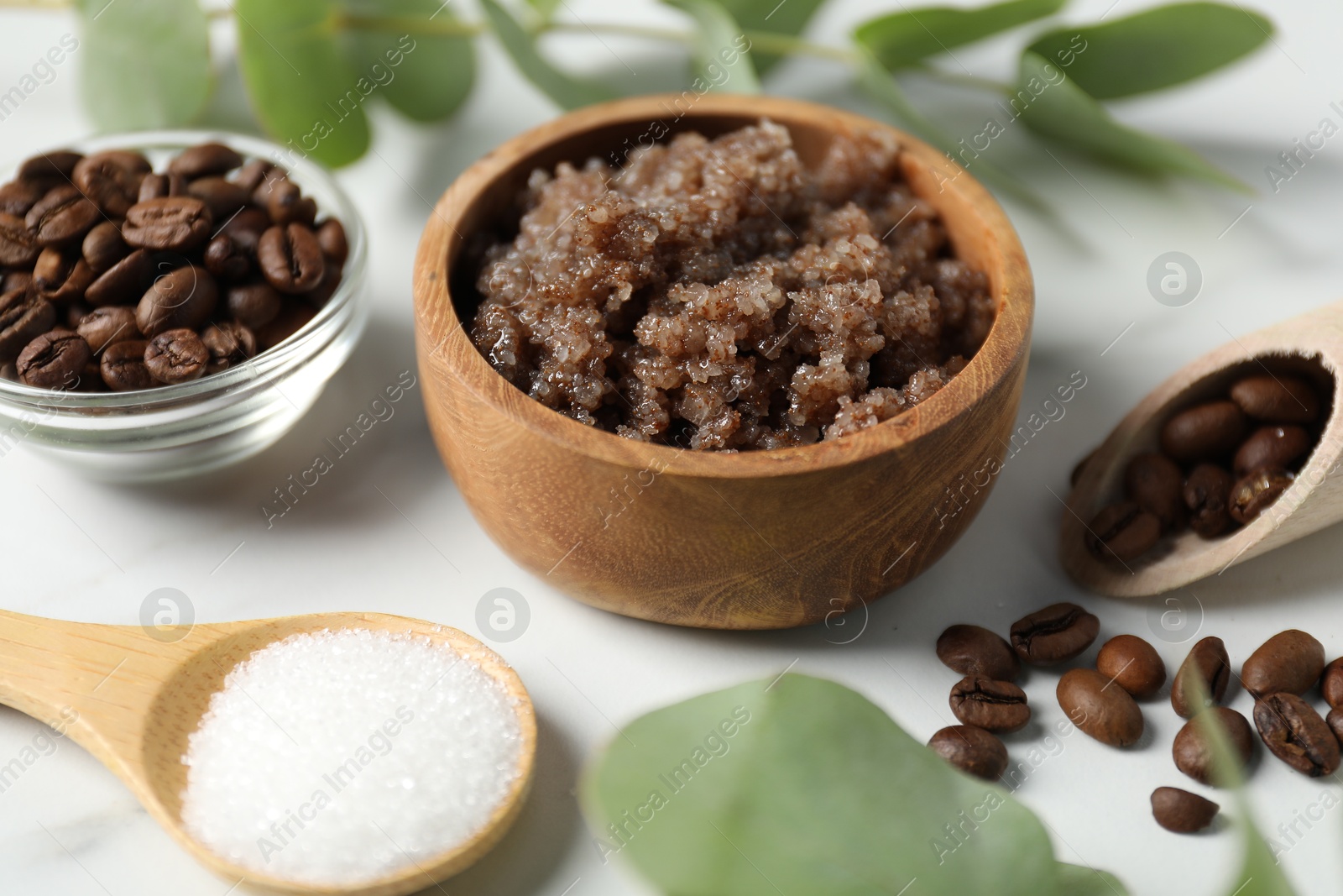 Photo of Natural body scrub and ingredients on white table, closeup