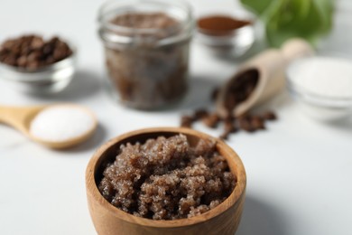 Photo of Natural body scrub and ingredients on white table, closeup