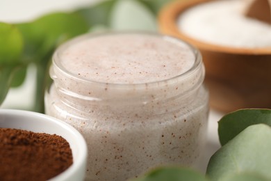 Photo of Natural body scrub and ingredients on white table, closeup