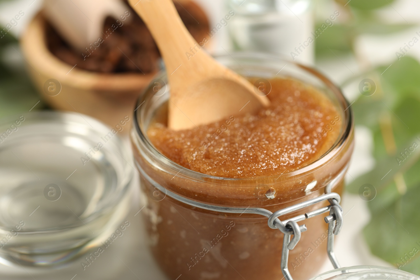 Photo of Natural body scrub and ingredients on white table, closeup