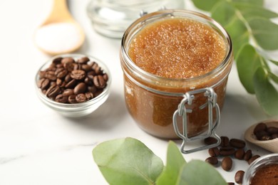 Photo of Natural body scrub and ingredients on white table, closeup