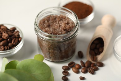 Photo of Natural body scrub and ingredients on white table, closeup