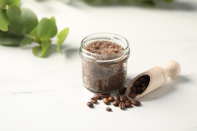 Photo of Natural body scrub and coffee beans on white table