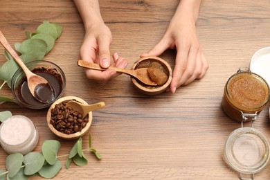 Photo of Woman making natural body scrub at wooden table, top view