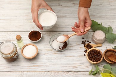 Photo of Making natural scrub. Woman adding sugar into bowl at white wooden table, top view