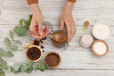 Photo of Woman making natural body scrub at white wooden table, top view