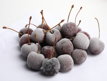 Photo of Heap of frozen cherries on white background