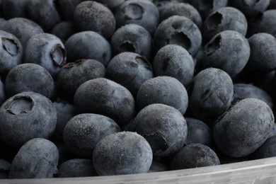 Photo of Heap of frozen blueberries in container, closeup