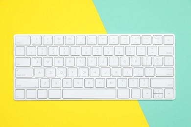 Photo of Modern white wireless keyboard on color background, top view