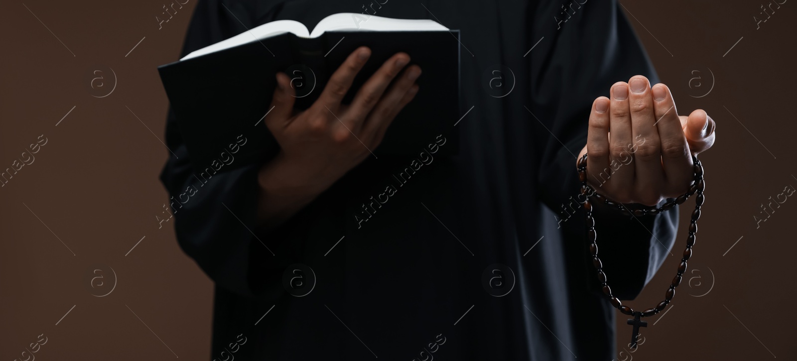 Photo of Priest with Holy Bible and rosary on brown background, closeup