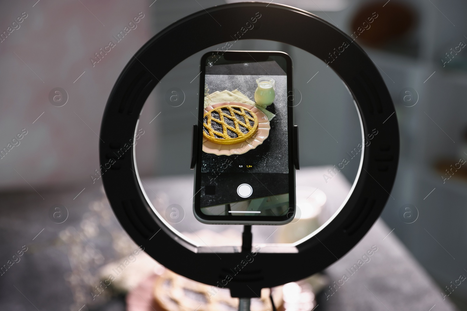 Photo of Shooting tasty pie and milk with smartphone in studio, selective focus. Professional food photography