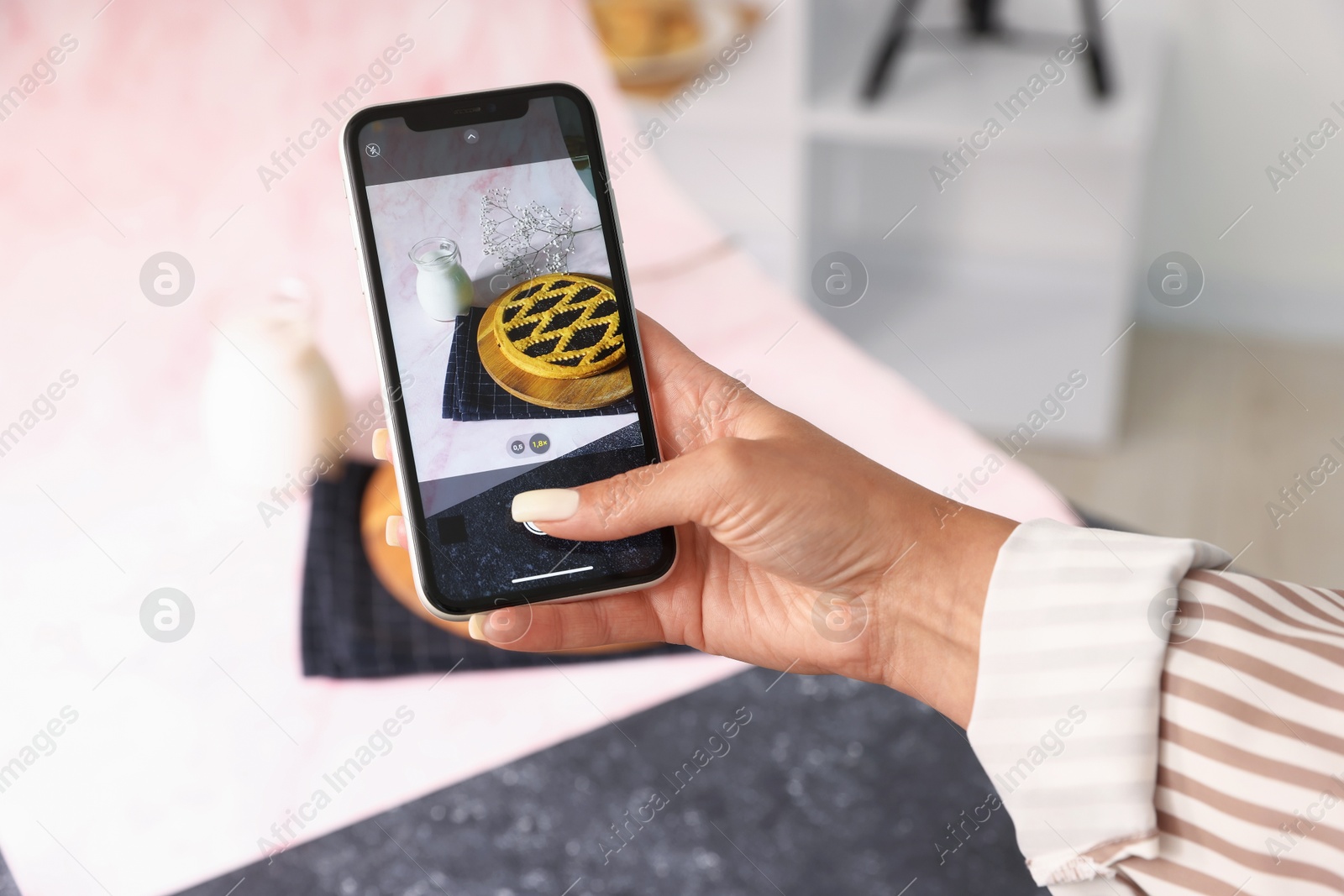 Photo of Woman taking picture of tasty pie and milk in studio, selective focus. Professional food photography