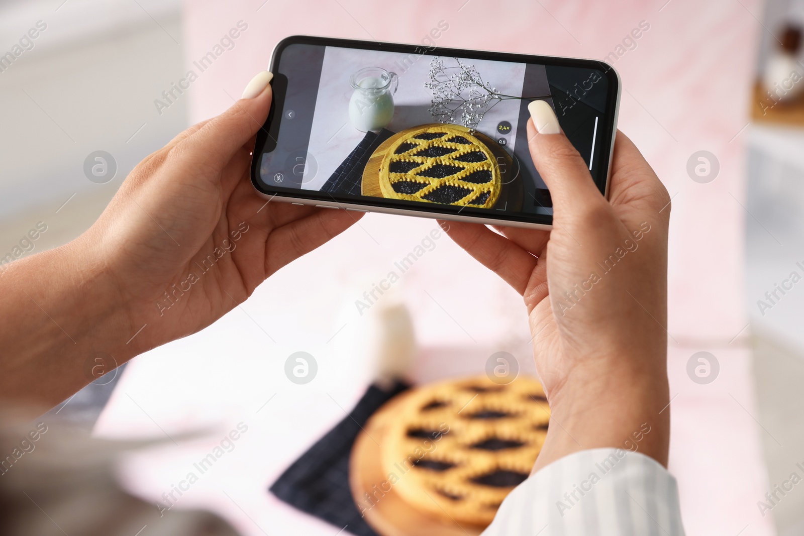 Photo of Woman taking picture of tasty pie and milk in studio, selective focus. Professional food photography