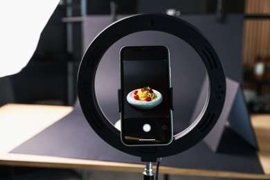 Photo of Shooting tasty pasta with smartphone in studio, focus on screen. Professional food photography